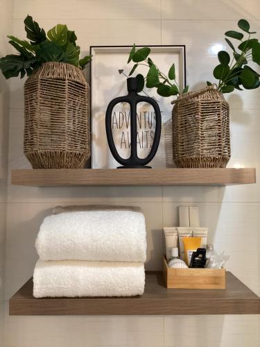 a shelf with two wicker baskets and a vase and towels at D' Residences in Cebu City