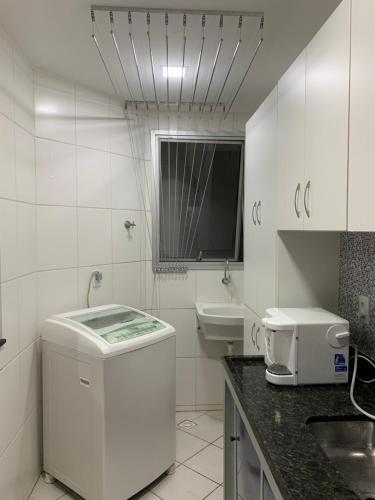 a white bathroom with a sink and a toilet at A dois passos do mar… in Vila Velha