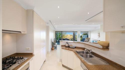 a kitchen with white cabinets and a sink at Unit 18 - 3 Bed Part Ocean View in Terrigal