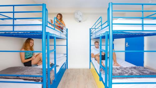 a group of people on bunk beds in a room at Global Backpackers Cairns in Cairns