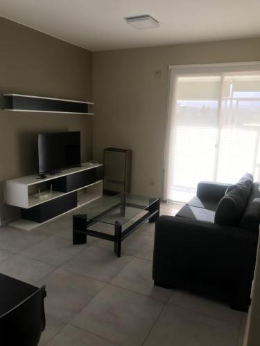 uma sala de estar com um sofá e uma televisão em Departamento nuevo em Mendoza