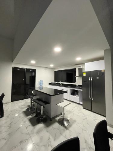 a kitchen with a table and a refrigerator at Villa lili, Carmen de Apicala condominio San Simon in Carmen de Apicalá