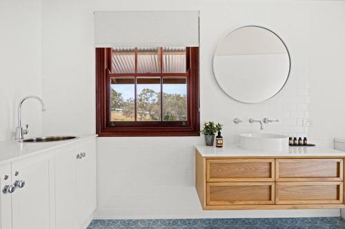 ein Bad mit einem Waschbecken und einem Spiegel in der Unterkunft Grandview Accommodation - Hideaway Huts in Dawesley