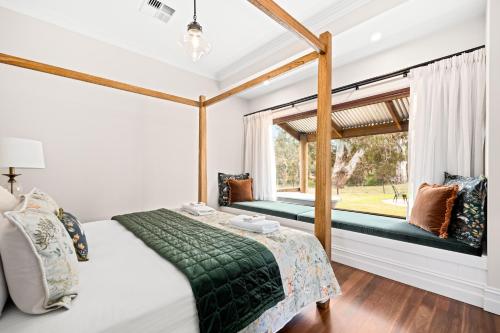 Schlafzimmer mit einem Bett und einem Fenster in der Unterkunft Grandview Accommodation - Hideaway Huts in Dawesley