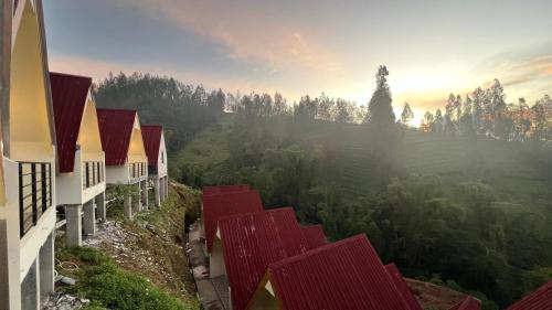 a row of houses on a hill with the sunset in the background at Hotel Nature Bromo and Resort in Pasuruan