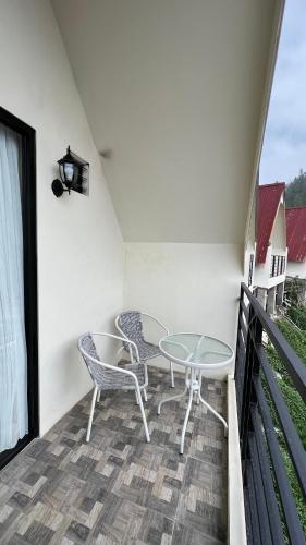 a patio with two chairs and a table on a balcony at Hotel Nature Bromo and Resort in Pasuruan
