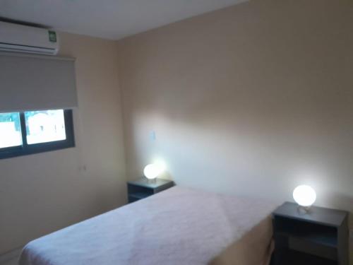 ein Schlafzimmer mit einem weißen Bett und zwei Nachttischen in der Unterkunft Complejo Villa Maria in Ciudad Lujan de Cuyo