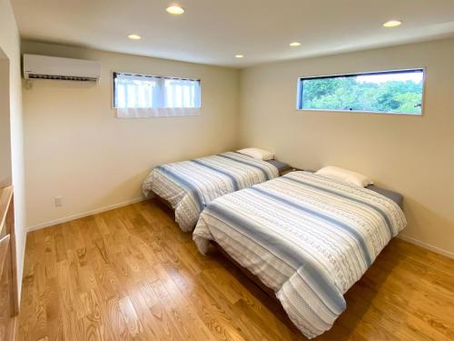 duas camas num quarto com duas janelas em Yonehara Beach Stay LUANA - Vacation STAY 38711v em Fukai
