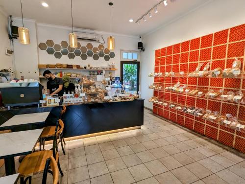 un homme debout au comptoir d'une boulangerie dans l'établissement Cottonwood Boutique Heritage Otten, à Bandung