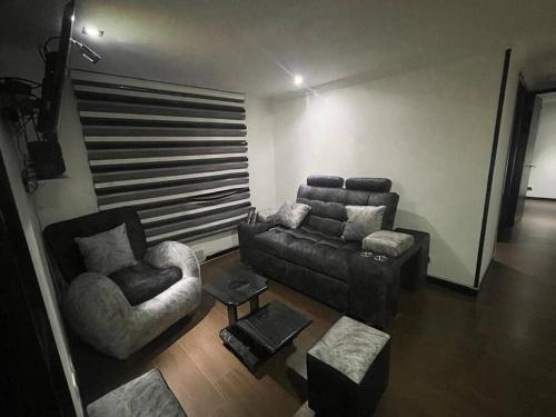 sala de estar con sofá y silla en Acogedor Apto Sector Tintal, en Bogotá