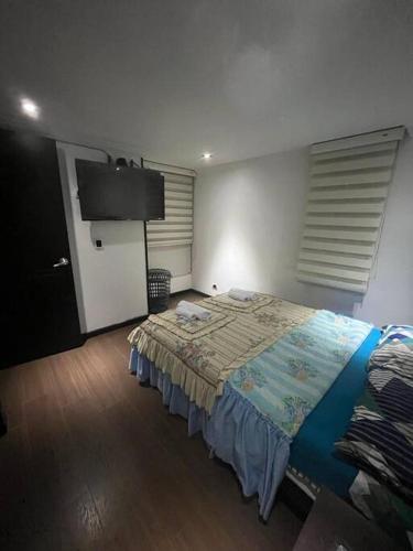 a bedroom with a bed and a flat screen tv at Acogedor Apto Sector Tintal in Bogotá