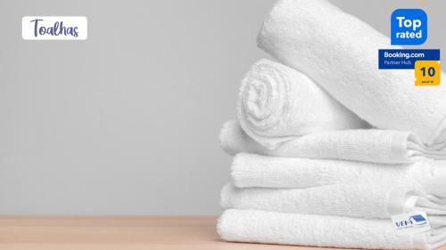stos białych ręczników z najwyższej klasy naklejką w obiekcie Apartamento Novo - Próximo ao Shopping Jardins w mieście Aracaju
