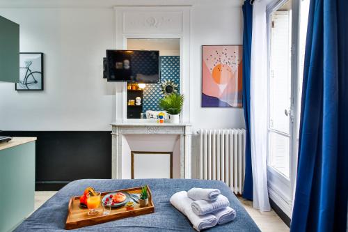 a room with a tray of food on a bed at Apartments WS Tour Eiffel - Laos in Paris