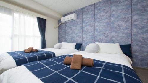two beds in a room with blue and white at Dia Palace Otemon 203 - Vacation STAY 12489v in Kanazawa