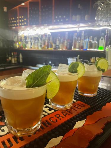 three drinks on a bar with lime slices on top at Harrietville Hotel Motel in Harrietville