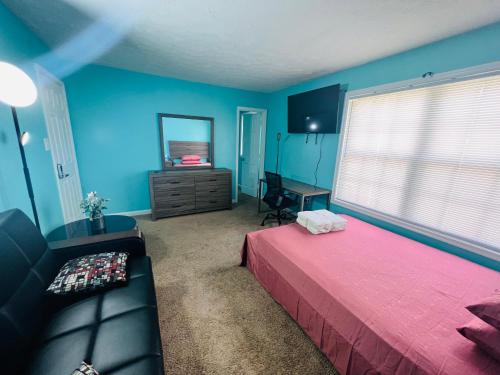 um quarto com paredes azuis, uma cama e um sofá em Private quiet room with shared Bathroom,kitchen,living and dining area em Clinton