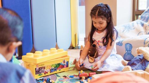 芭達雅南區的住宿－InterContinental Pattaya Resort, an IHG Hotel，坐在地板上玩玩具的小女孩