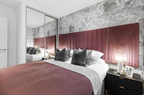 Schlafzimmer mit einem großen Bett mit einem roten Kopfteil in der Unterkunft Luxury Modern, One bedroom Flat in Olton