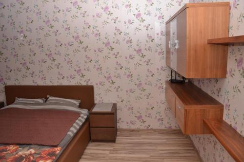 Dormitorio pequeño con cama y flores en la pared en Imanta Apartment Riga 2х Rooms 52м2, en Riga