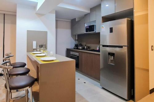 a kitchen with a refrigerator and a counter with stools at Elegant 1-bedroom apartment in San Isidro - Peru (65m2) in Lima