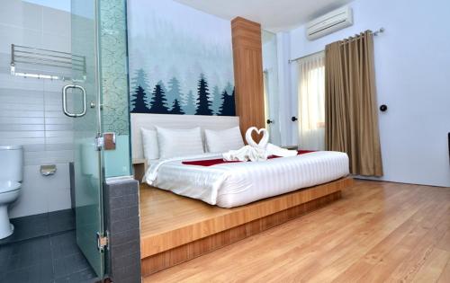 a bedroom with a large bed and a shower at Hip Hope Hotel Banda Aceh in Banda Aceh