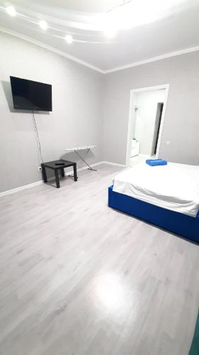 a bedroom with a bed and a flat screen tv at Жк ривьера in Kokshetau