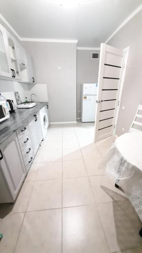 a kitchen with white appliances and a white door at Жк ривьера in Kokshetau