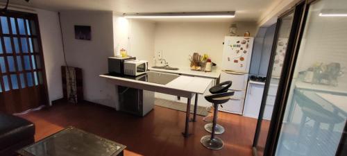 a kitchen with a counter with a microwave and a refrigerator at Casa de Verano in Iquique