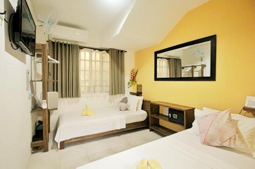 een hotelkamer met 2 bedden en een spiegel bij Bulskamp Inn in El Nido