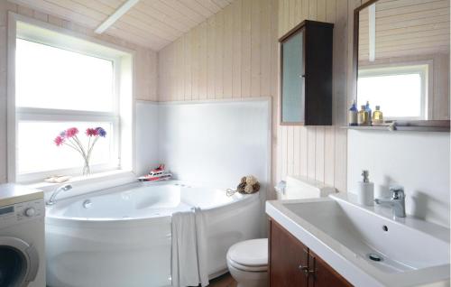 ein Badezimmer mit einer Badewanne, einem WC und einem Waschbecken in der Unterkunft Strandblick 1 in Schönhagen