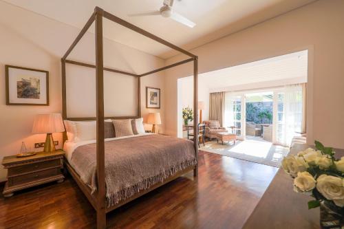 a bedroom with a canopy bed and a living room at W15 Hanthana Estate Kandy in Kandy