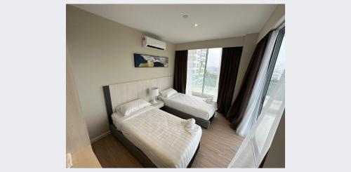 1 dormitorio con 2 camas y ventana en ARU SUITES 3BR Nilam Residence INFINITY POOL, en Kota Kinabalu