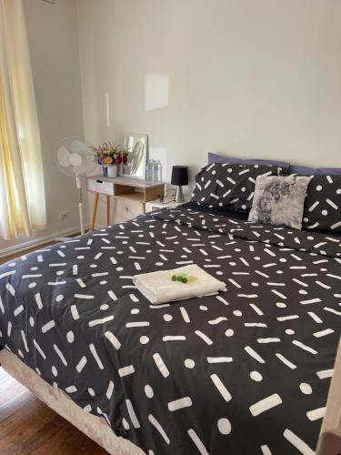a bedroom with a bed with a black and white comforter at Private Room Near Melbourne Airport in Deer Park