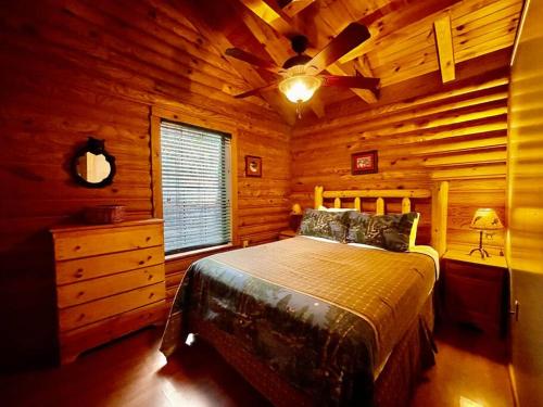 um quarto com uma cama num chalé de madeira em Good Life Cabin 2 em Bryson City