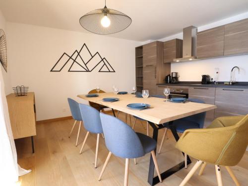 une cuisine et une salle à manger avec une table et des chaises dans l'établissement Appartement raffiné en plein centre avec 3 chambres, balcon, terrasse, parking et wifi - FR-1-623-334, aux Gets