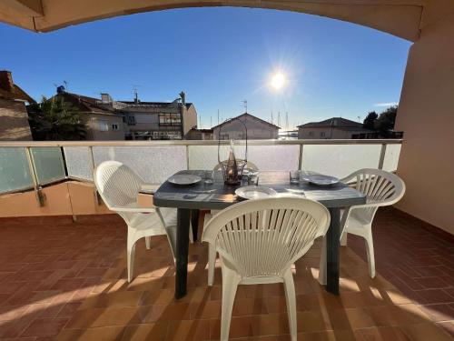 une table noire et des chaises sur un balcon dans l'établissement T2 avec terrasse et parking, proche plage, 4 pers - FR-1-701-44, à Valras-Plage