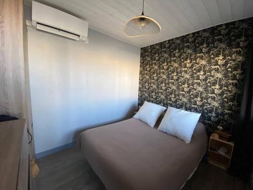 - un lit avec 2 oreillers blancs dans l'établissement Appartement T2 + cabine avec climatisation, parking, proche plage à Port Leucate - FR-1-81-579, à Port-Leucate