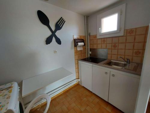 eine Küche mit einem Waschbecken und einer Gabel an der Wand in der Unterkunft Appartement Le Grau d'Agde, 3 pièces, 6 personnes - FR-1-423-261 in Le Grau-dʼAgde