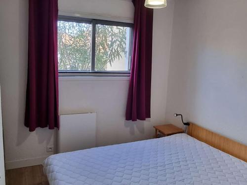 une chambre avec un lit blanc et une fenêtre dans l'établissement Charmant T3 rénové, jardin privatif, plage à pied, clim, parking, 4 pers. - FR-1-607-153, au Cap d'Agde