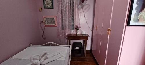 a small room with a bed and a table at Donsol Aguluz Homestay in Donsol
