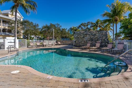 uma grande piscina com cadeiras e palmeiras em - The Bonita Paddle A202 - Beautiful Bonita Springs Condo with Mother In Law Suite! condo em Bonita Springs
