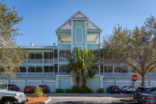 um edifício azul com uma árvore em frente em - The Bonita Paddle A202 - Beautiful Bonita Springs Condo with Mother In Law Suite! condo em Bonita Springs