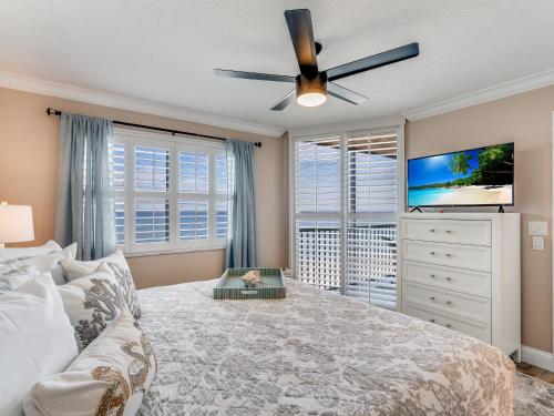 フォートマイヤーズビーチにあるTwo-Bedroom Apartmentの天井ファン付きの大きなベッドのある寝室