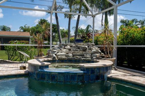 einen Pool im Garten mit Steinbrunnen in der Unterkunft Barefoot Hideaway, with Spa and Pool home in Bonita Springs