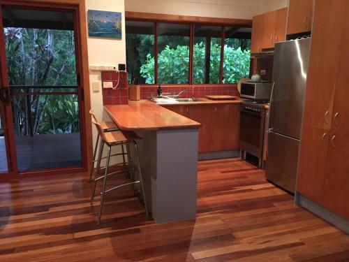 cocina con suelo de madera y electrodomésticos de acero inoxidable en Kin Kin Cottage Retreat, en Kin Kin