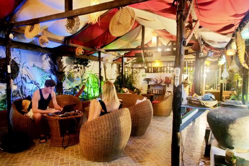 a man and woman sitting in chairs in a restaurant at Bulskamp Inn in El Nido