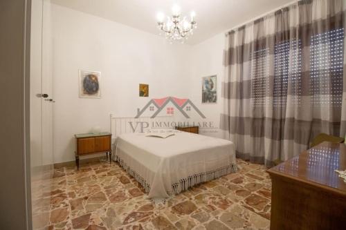 een slaapkamer met een bed en een kroonluchter bij 2-bedroom apartment in heart of Tuscany with free parking in Pomarance