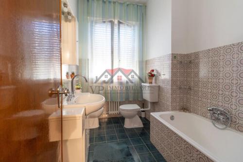 een badkamer met een wastafel, een bad en een toilet bij 2-bedroom apartment in heart of Tuscany with free parking in Pomarance