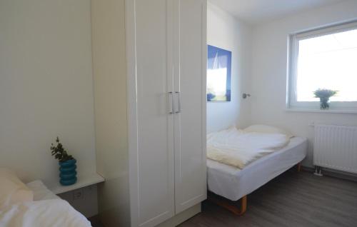 Cette chambre blanche dispose d'un lit et d'une fenêtre. dans l'établissement Appartement Seestern A, à Schönhagen