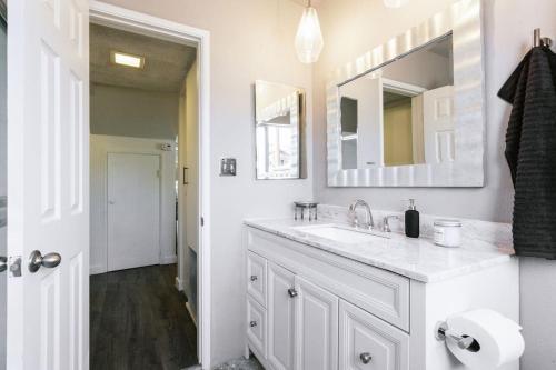 a white bathroom with a sink and a mirror at Hillside Haven in San Diego